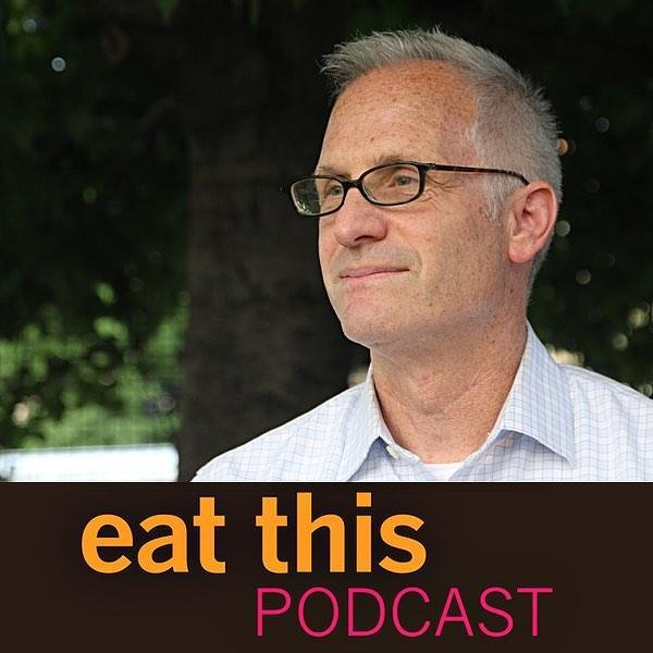 Auto-generated description: A man wearing glasses and a striped shirt stands outdoors, with the text eat this PODCAST displayed at the bottom.