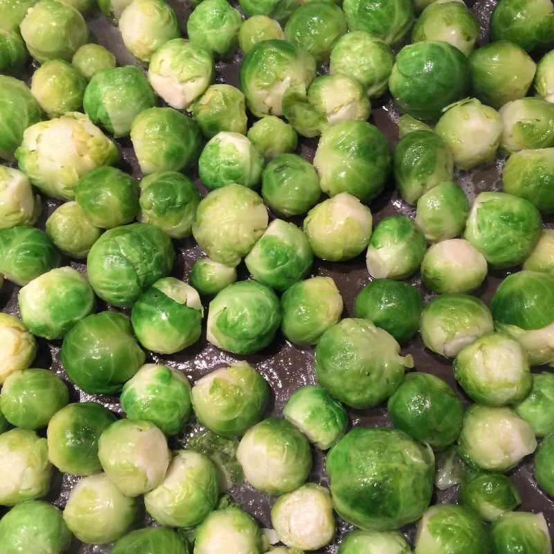 Auto-generated description: A collection of fresh Brussels sprouts is spread out, showcasing their vibrant green color.